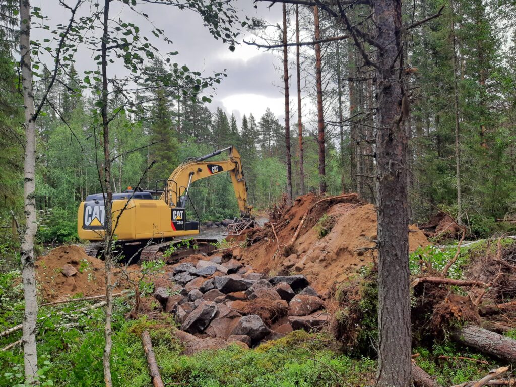 Grävmaskin i skogen.